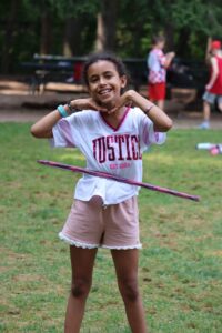 day camp. grow, learn, and make lasting memories. Girls standing using a hoola hoop.