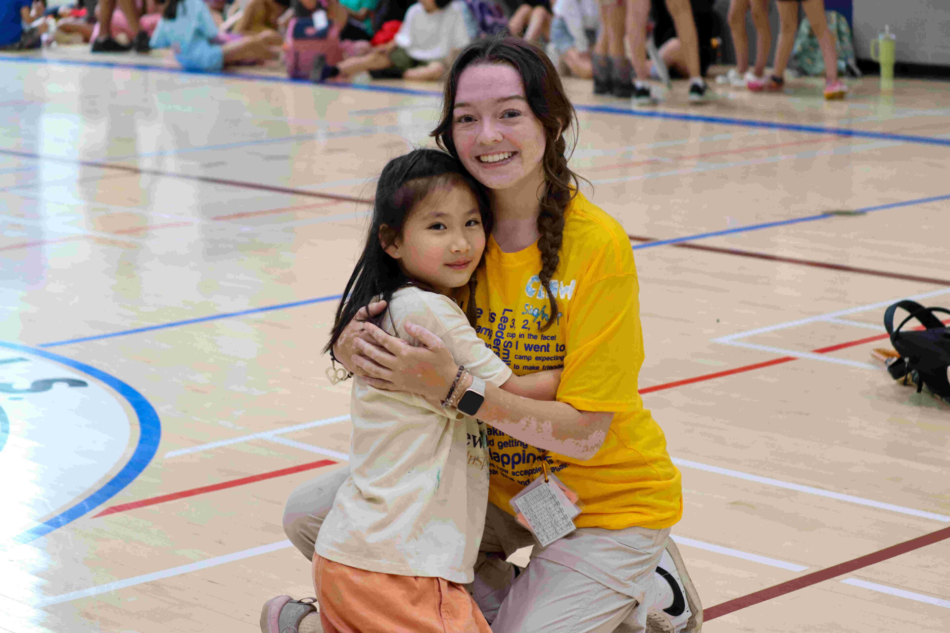 Day Camping. Counsellor hugging young camper.